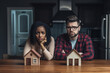 © PicMedia - Mixed race unhappy couple sitting and thinking about home finances. Home loan, family, bankruptcy, taxes, money, accounting and financial problems concept.