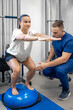 © puhimec - Balance exercise with bosu ball, woman and doctor in gym.