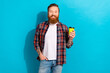 © deagreez - Portrait of cool man with tattoo wear plaid shirt holding cup of coconut milk latte arm in pocket isolated on blue color background
