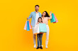 © Prostock-studio - Happy family holding shopping bags and smiling, parents and their daughter posing with colorful paper shoppers