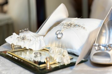 Wall Mural - Closeup of wedding accessories featuring two gold rings, a white bridal bouquet