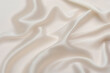 eige cream or ivory silk satin. Draped fabric. Light pale brown luxury background for design. Flat lay, top view table.