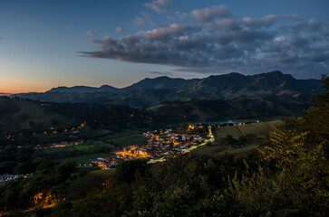 Wall Mural - Scenic landscape of a town behind mountains in the evening