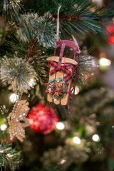 Poster - Vertical shot of a small Christmas decoration hanging from the Christmas tree