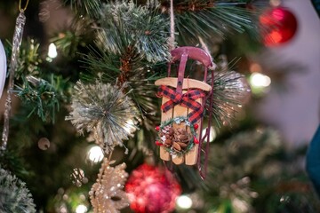 Poster - Small Christmas decoration hanging from the Christmas tree on the blurred background