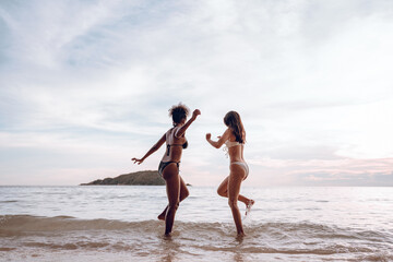 Sticker - Happy beauty woman in bikini walking and playing together on the beach having fun in a sunny day, Beach summer holiday sea people concept.