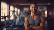 © Tetiana - Muscular African American man in grey sportswear, fitness trainer smiling and looking at the camera on the background of the gym. The concept of a healthy lifestyle and sports.