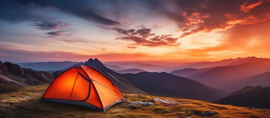 Poster - Vibrant orange tent beneath dramatic sunset in mountainous summer panorama