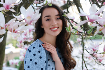 Poster - Beautiful woman near blossoming magnolia tree on spring day