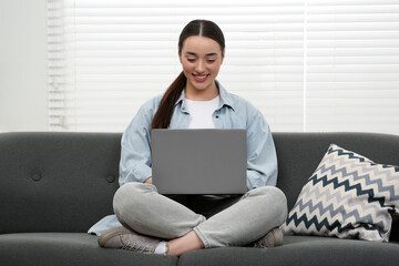 Canvas Print - Woman using laptop on couch at home