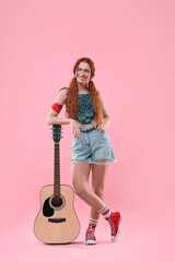 Wall Mural - Stylish young hippie woman with guitar on pink background