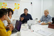 © DragonImages - Emotional team leader taking to his team in daily meeting