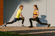 © Drobot Dean - Positive couple doing stretching exercises together outdoors at street