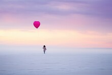 A Person Flying A Kite Over The Vast Expanse Of The Ocean