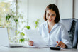 © Sandu - Accountant woman doing work at her desk with paper and calculator.