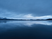 View Of A Lake In A Winter Blue Hour In The Evening. The Water Makes A Mirror Effect To The Sky