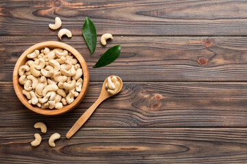 Wall Mural - cashew nuts in wooden bowl on table background. top view. Space for text Healthy food