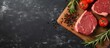 Farm organic meat recipes featuring raw meat steaks rosemary wood cutting board tomatoes on a dark marble background no people in the photo isolated pastel background Copy space