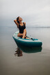 © UnPinky - Attractive girl in a swimsuit rides a SUP in the sea early in the morning