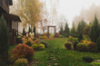 autumn garden view in october with wooden archway. Rustic natural fall garden