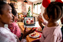 Young African American Family Talking To Santa On A Video Call On The Laptop During The Christmas And New Year Holidays At Home