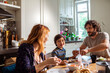 © Marko Geber - Young Caucasian family having breakfast together in the morning in the kitchen at home