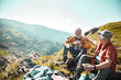 © Marko Geber - Two senior male friends taking a break from hiking and having a snack in the mountains