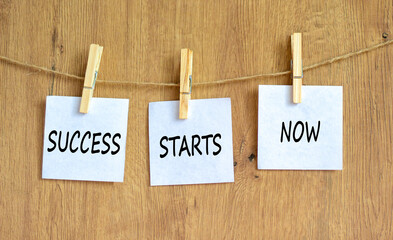 Wall Mural - Success starts now symbol. Concept word Success starts now on beautiful white paper on wooden clothespin. Beautiful wooden background. Business motivational success starts now concept. Copy space.