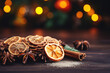 Traditional Christmas spices and dried orange slices on holiday bokeh background with defocus lights. Cinnamon sticks, star anise, pine cones and cloves