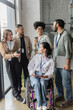 © LIGHTFIELD STUDIOS - group shot of diverse startup team looking at each other in office, wheelchair user, inclusion