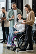 © LIGHTFIELD STUDIOS - disabled woman in wheelchair looking at tablet, discussing startup project with interracial team