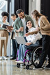 © LIGHTFIELD STUDIOS - disabled woman in wheelchair discussing startup project with happy interracial team in coworking