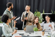© LIGHTFIELD STUDIOS - cheerful multiethnic business team generating ideas and discussing startup project in coworking