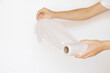 Female hands hold a roll of disposable plastic bags on a white background, disposable bags, plastic bag, ecology