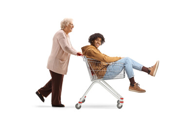 Poster - Elderly woman pushing an african american guy in a shopping cart