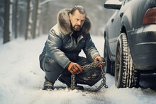 man putting snow chains on his car
