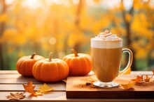 Delicious Fall Pumpkin Latte On A Wooden Table With Autumn Leaves And Copy Space