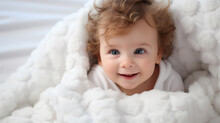 Close-up Portrait Of A Baby Wrapped In A Blanket On The Bed And Looking At The Camera. Concept For Advertising Health And Products For Babies