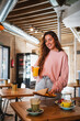 © Pablo Rasero - Cute young woman putting her food on the table. She is having brunch at a cafeteria.
