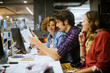 © Geber86 - Young group of coworkers going over paperwork in the office of a startup company