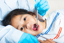 Dental Kid Health Examination. Doctor Examines Oral Cavity Of Little Child Uses Mouth Mirror To Checking Teeth Cavity, Asian Dentist Making Examination Procedure For Smiling Cute Little Girl