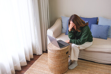 Canvas Print - Portrait image of a young woman using laptop computer for video call and working or studying online at home