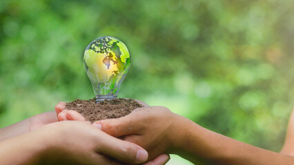 Business partners create energy, sustainable renewable energy concepts, and environmental protection The green world map is placed on the light bulb representing green energy.