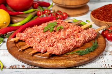 Wall Mural - Adana kebab on wood background. Raw shish adana kebab with herbs and spices. Close up