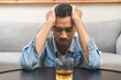 Health care alcoholism drunk, fatigue asian young man drinking beverage on table, alone depressed male drink booze on sofa at home. Treatment of alcohol addiction, suffer abuse problem alcoholism.