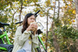 © MIND AND I - Young woman eating meal at park.