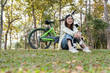 © MIND AND I - Young woman sitting and relaxing at park.