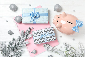 Wall Mural - Piggy bank, gift boxes, notepad and fir branches on white background, top view