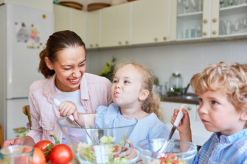 Daughter enjoying eating salad with family at home