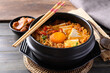 Korean spicy noodle soup with kimchi, tofu, egg and mushroom in Korean stone bowl